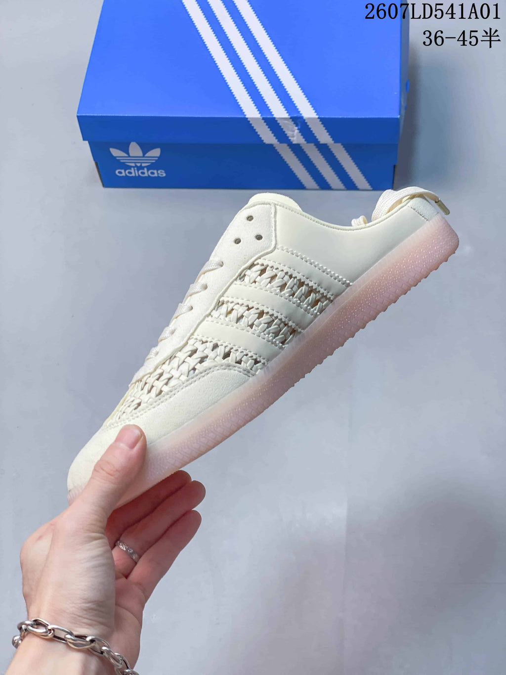 Side view of the sneaker showing woven-look panels, three stripes, and an open heel.