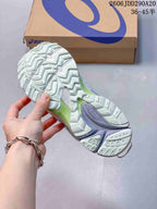 Close view of the patterned outsole showing segmented tread and green and lavender midsole accents.