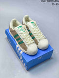 Pair of beige and green Adidas Superstar-style sneakers displayed on a blue Adidas shoebox; overlay text shows style code 2607JDD735A05 and size range 35–45.