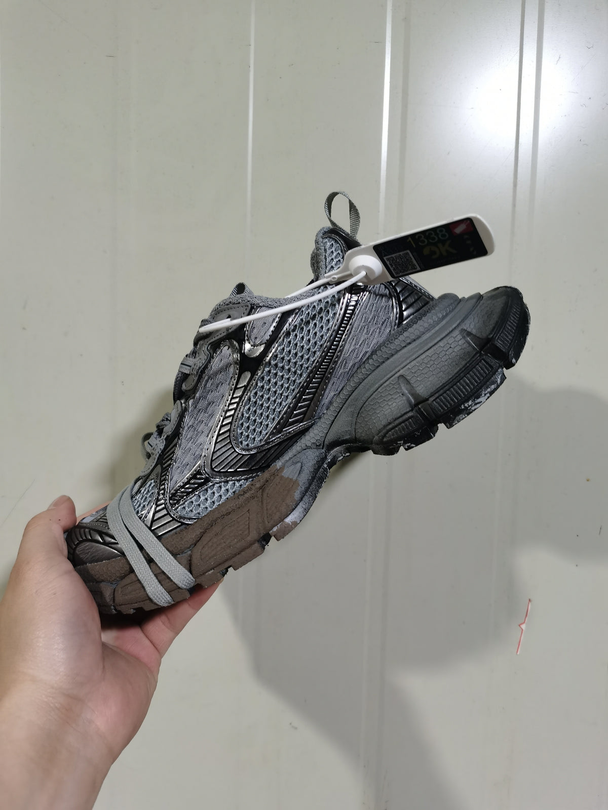Side view of the grey and black mesh sneaker showing layered overlays, laces, and chunky outsole.