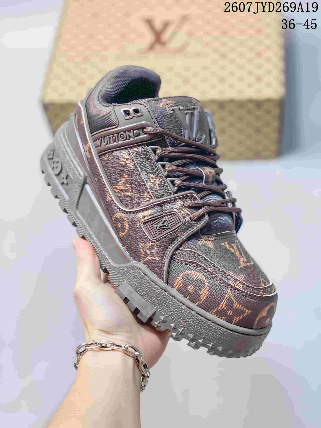 Angled front-side view of the brown Louis Vuitton Trainer Maxi sneaker showing the lace system, monogram panels, logo details, and textured outsole.