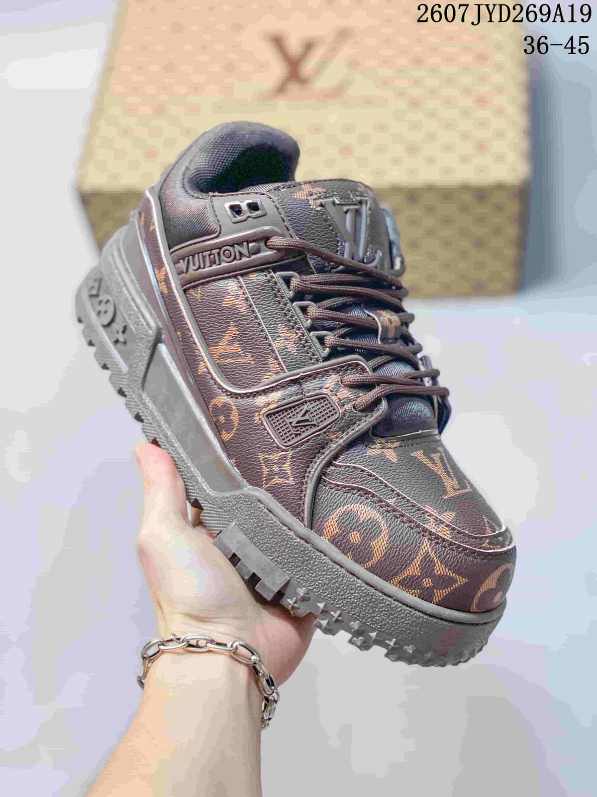 Angled front-side view of the brown Louis Vuitton Trainer Maxi sneaker showing the lace system, monogram panels, logo details, and textured outsole.