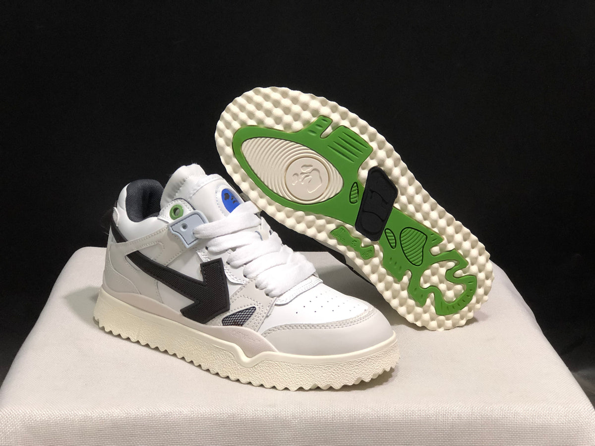 Angled view of one sneaker with the outsole exposed, showing green and black tread accents.