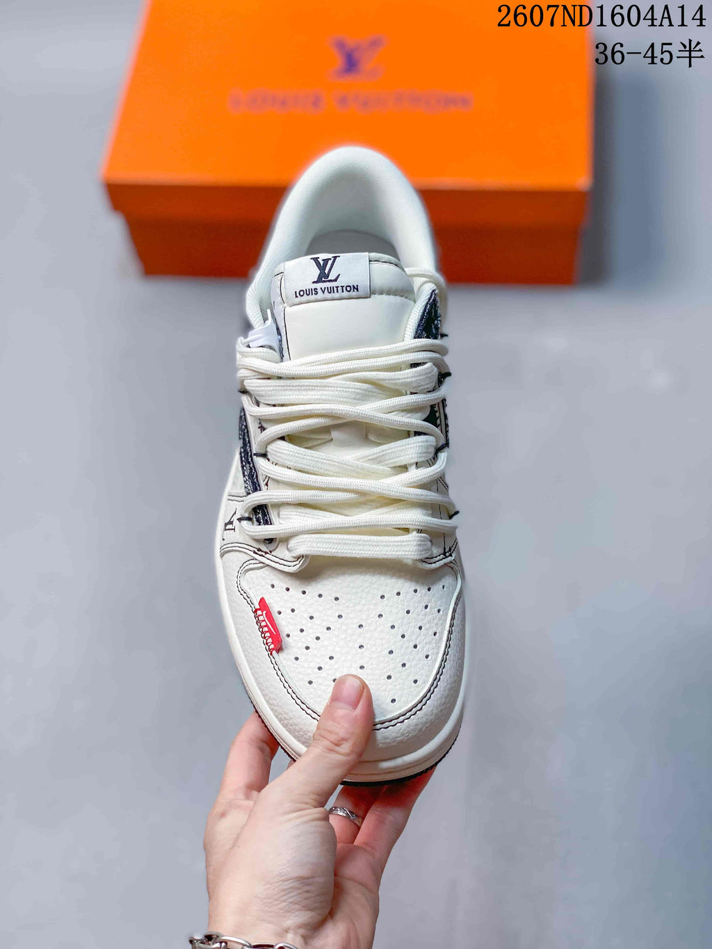 Top view of the sneaker showing white laces, a perforated toe box, and branded tongue detailing.