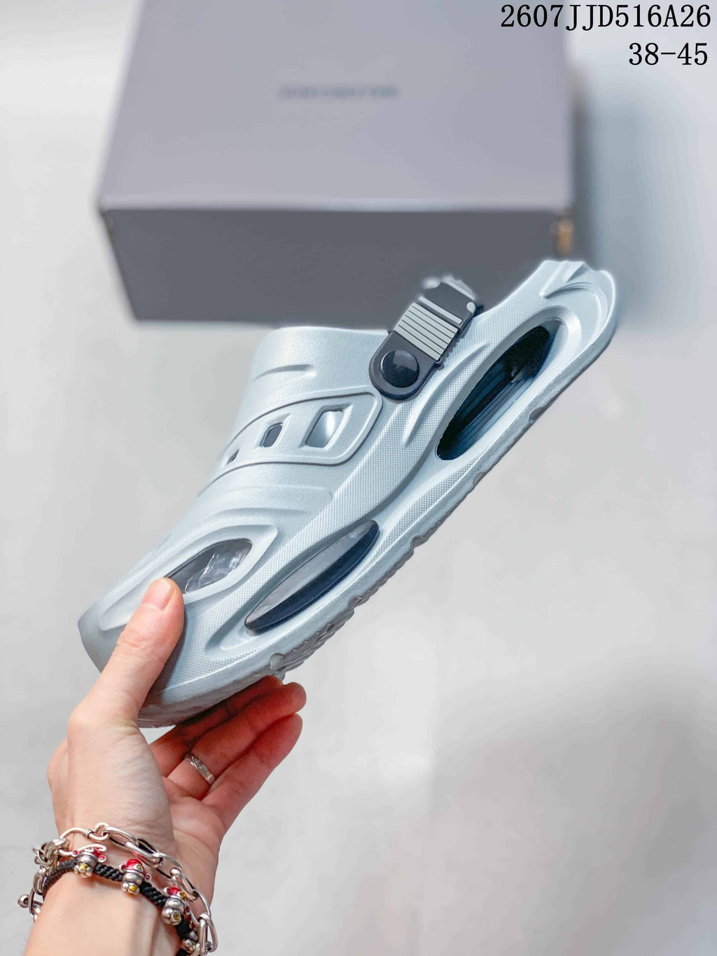 Side view of the light gray clog sandal highlighting the platform sole, side cutouts, and heel strap attachment.