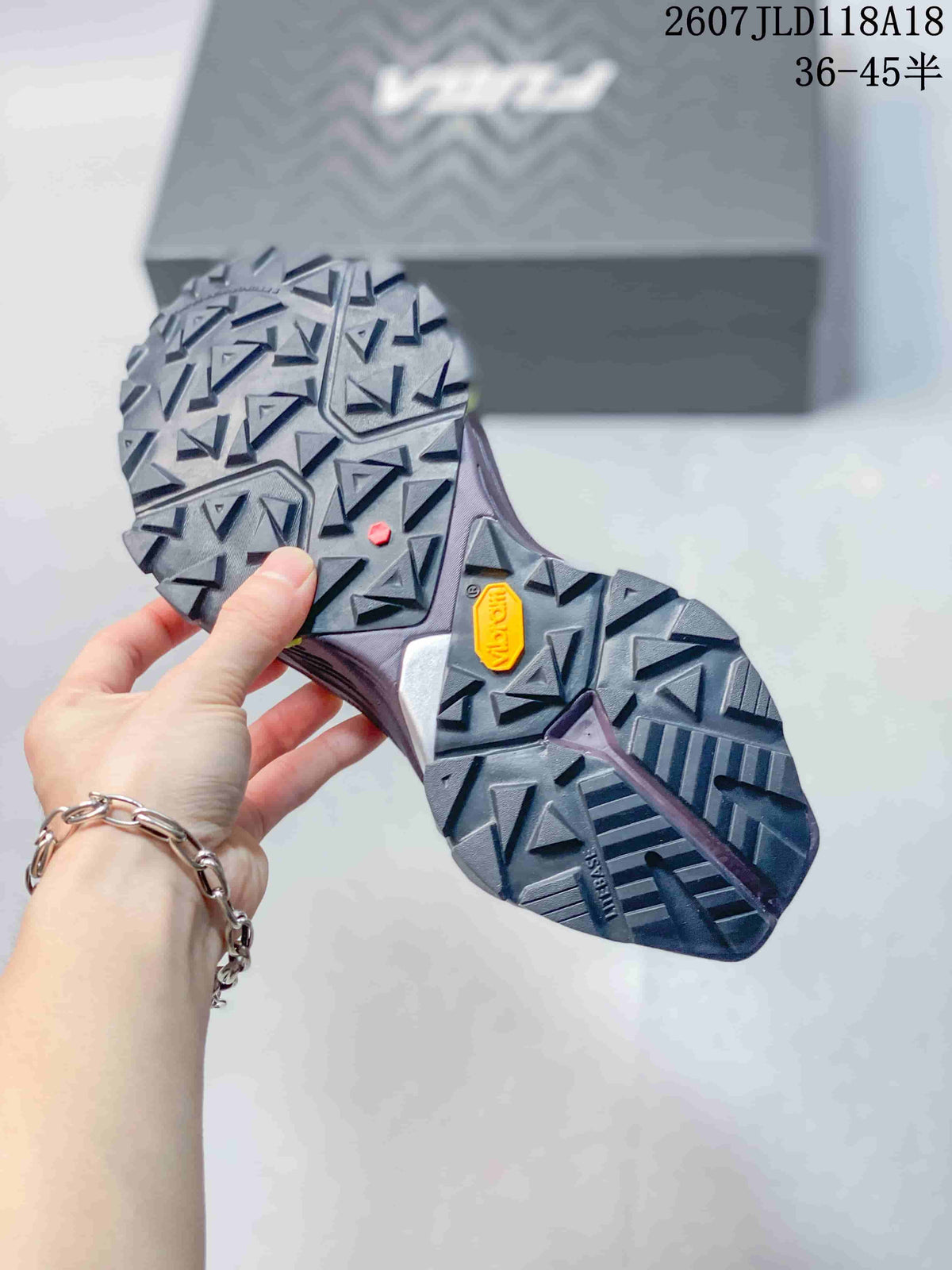 Close view of the lugged outsole with angular traction blocks and a visible Vibram mark.