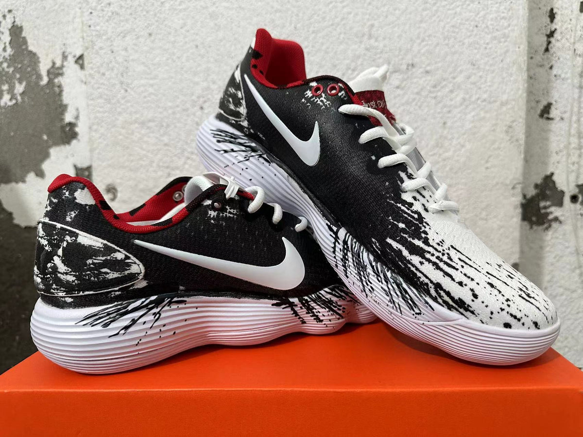 Pair of black-and-white patterned Nike shoes with red accents and white soles