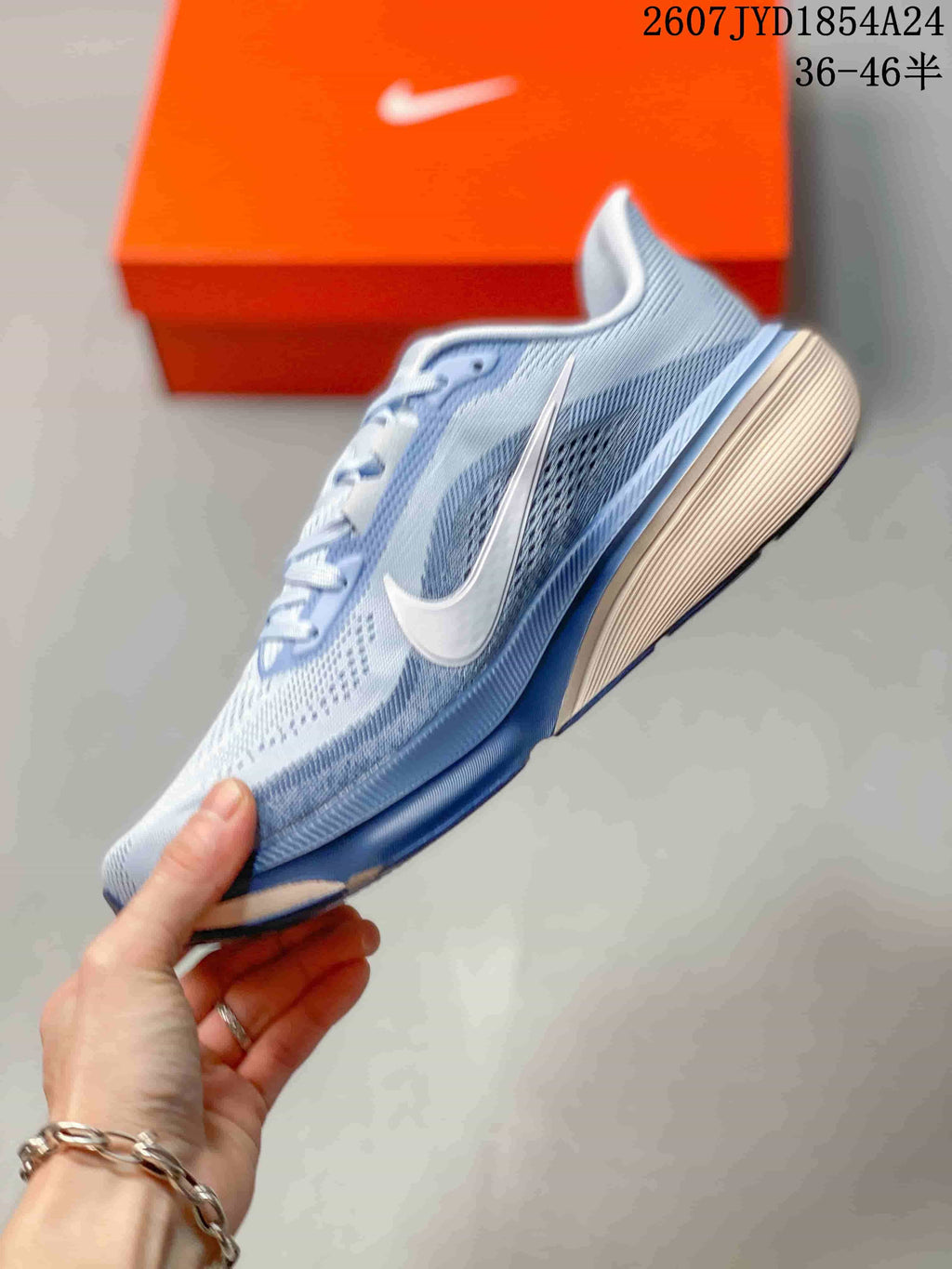 Side profile showing the light blue upper, white Swoosh, cushioned midsole, and blue outsole.