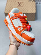 Angled side view highlighting the white and orange low-top design, branded side details and orange outsole.