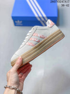 Side view highlighting the light-gray upper, pink patterned stripes, and platform sole.