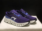 Three-quarter view of the purple and blue On Cloudmonster 3 shoes with white sculpted midsoles.