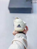 Rear view of an off-white sneaker showing adidas branding on the heel.