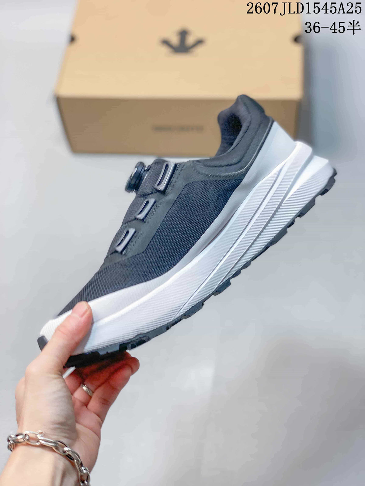 Side profile showing the dark mesh-look upper, layered white midsole, and dark outsole.