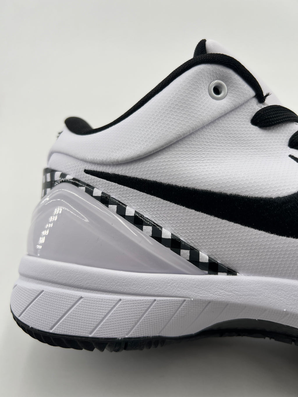 Close-up of the white shoe heel, black Swoosh, and checkerboard trim