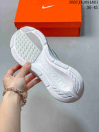 Underside view showing the tread pattern and sculpted sole of the white running shoe