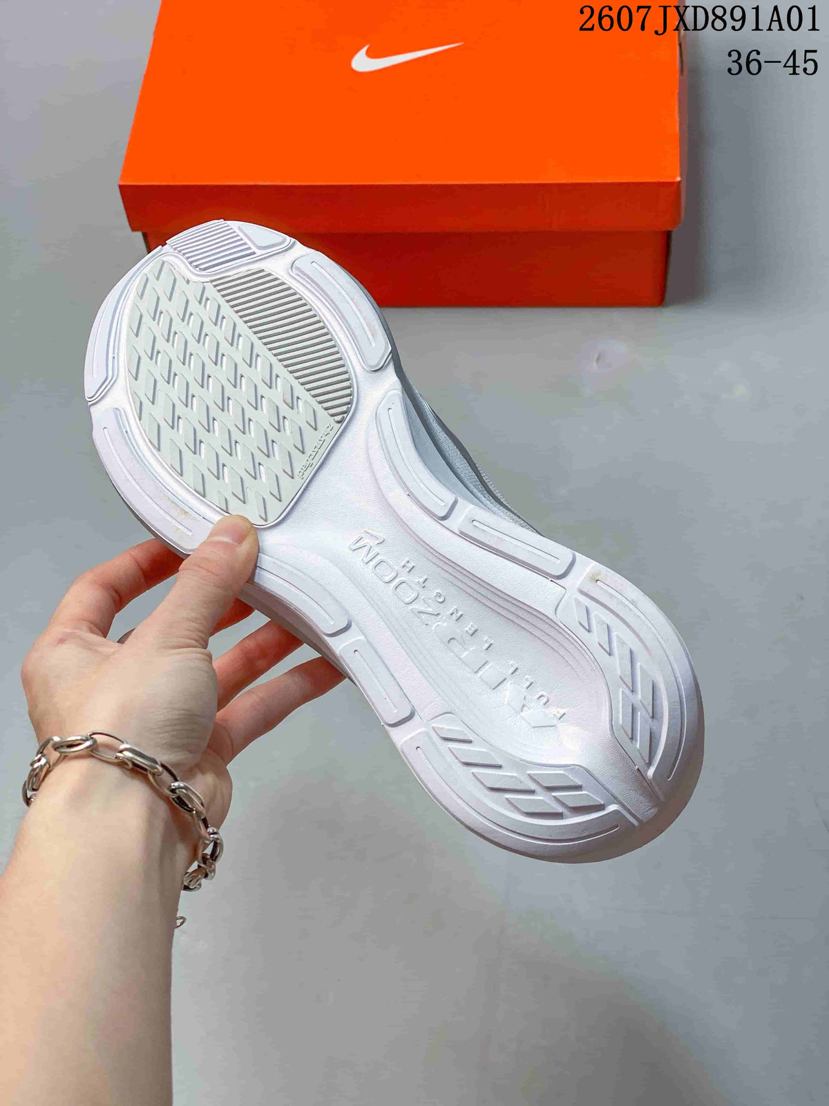 Underside view showing the tread pattern and sculpted sole of the white running shoe
