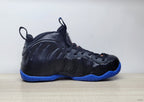 Side profile of a black Nike Air Foamposite Pro high-top sneaker with a bright blue sole.