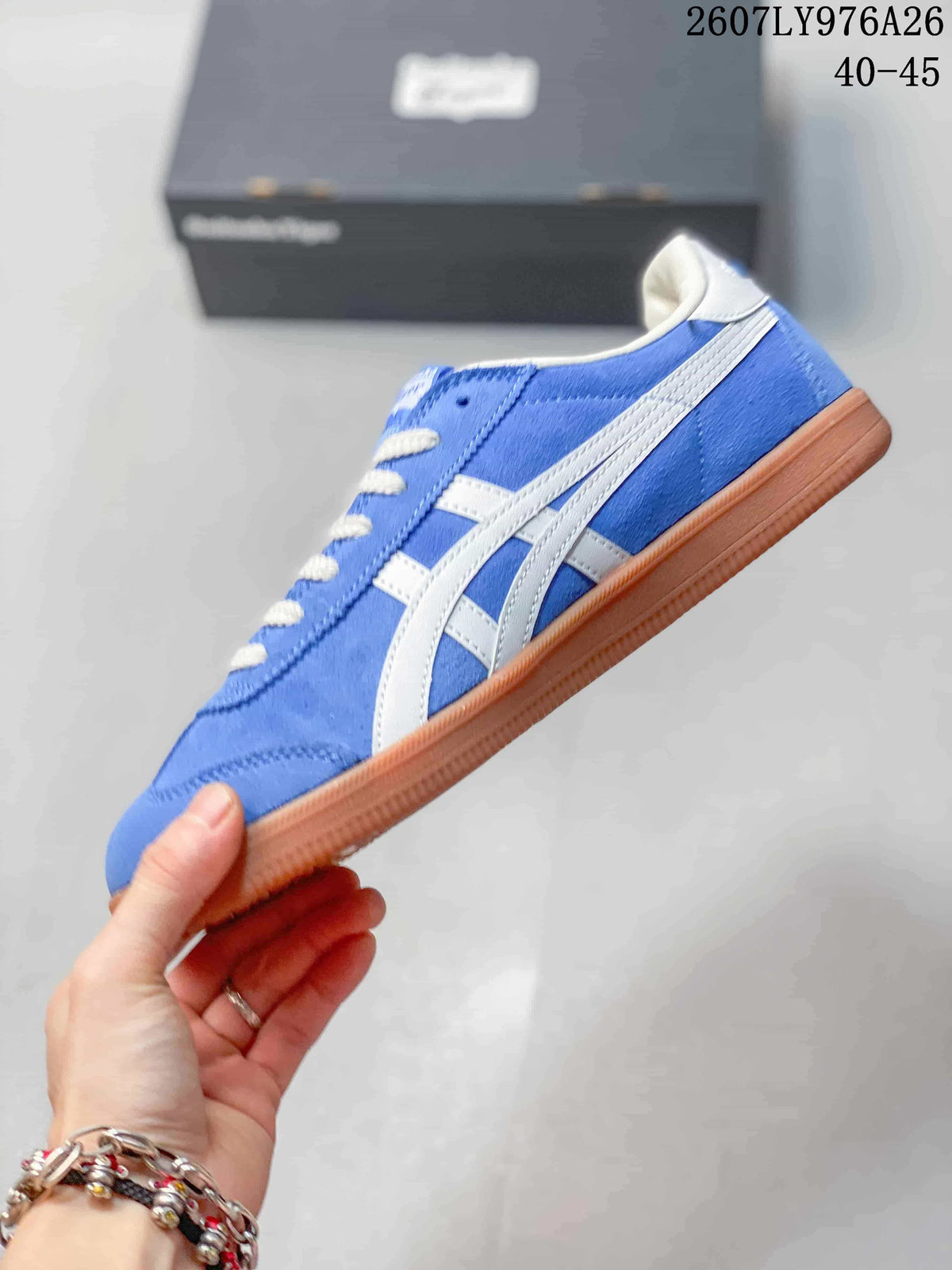 Side view of the blue low-top sneaker with white contrasting stripes and a gum-colored outsole.