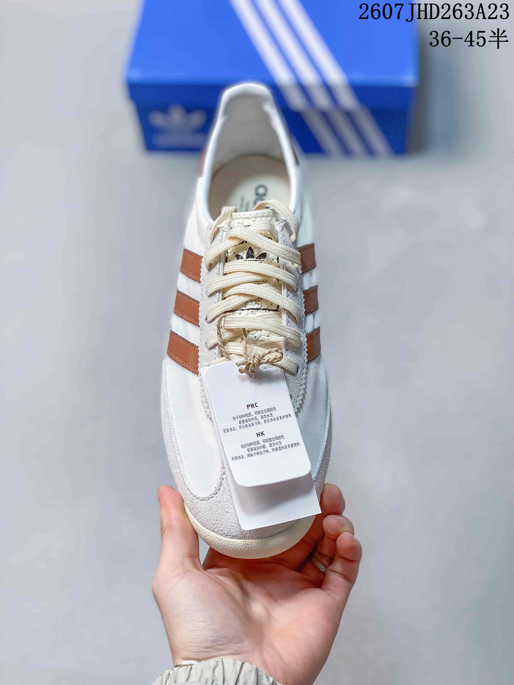 Top view showing the cream laces, brown side stripes and adidas branding on the tongue.