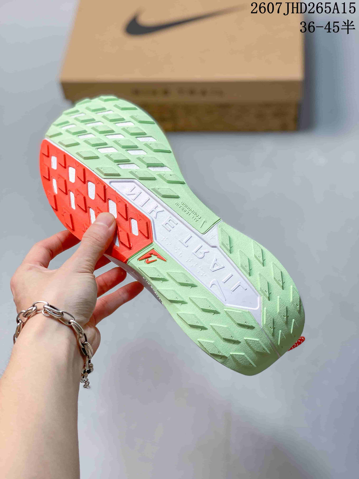 Close view of the Nike Pegasus Trail 5 outsole showing green and orange sections with a patterned tread.