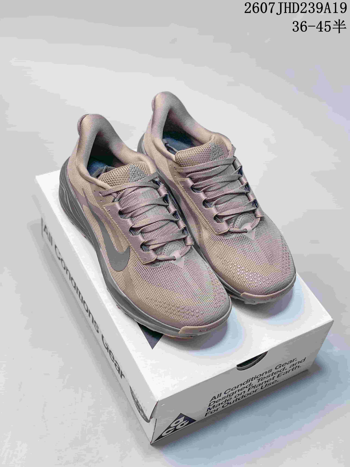 Pair of mauve-gray Nike ACG Pegasus Trail sneakers displayed on a shoebox.
