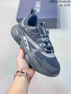 Three-quarter side view of the dark gray Dior sneaker showing its layered upper, pull tabs, and chunky sole.