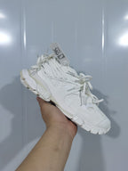 Angled view of a white Balenciaga lace sneaker showing the layered upper, tonal laces, and chunky sole.