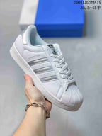 White adidas Superstar sneaker with silver serrated stripes, shell toe and image code 2607LD299A19.