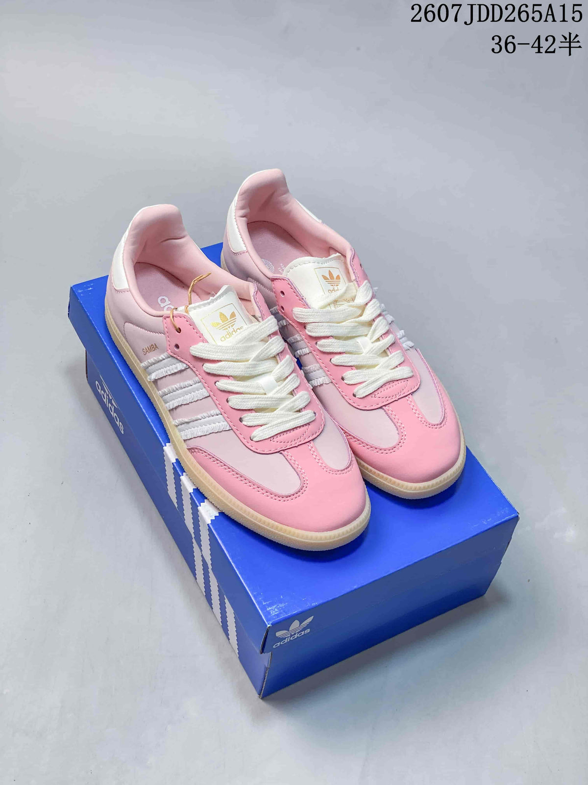 Pair of pink adidas Samba low-top sneakers displayed on a blue adidas shoebox; the source image shows style code JDD265A15 and a size range caption.