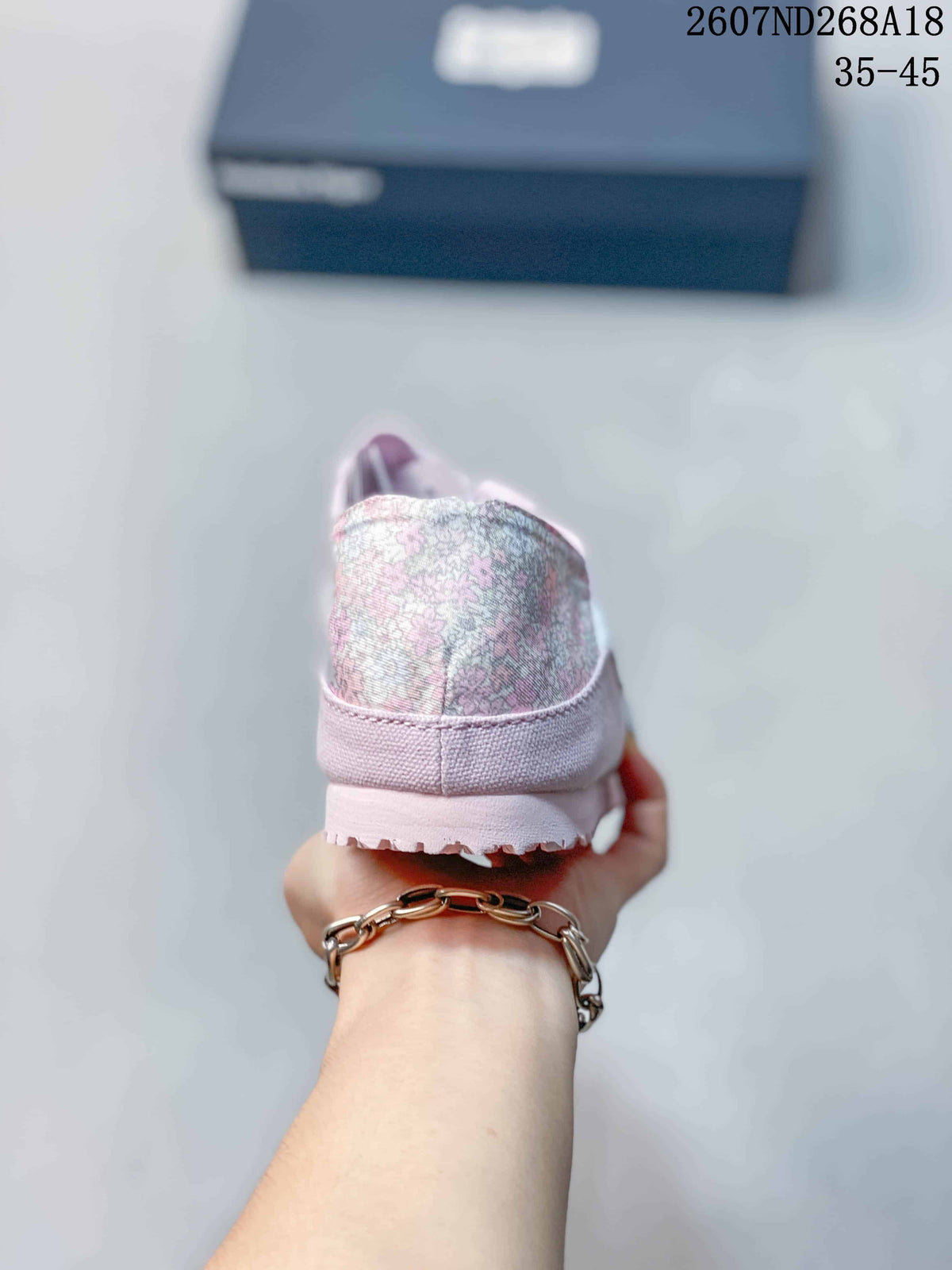 Rear view of the sneaker showing the patterned fabric heel panel, pink collar and textured outsole edge.