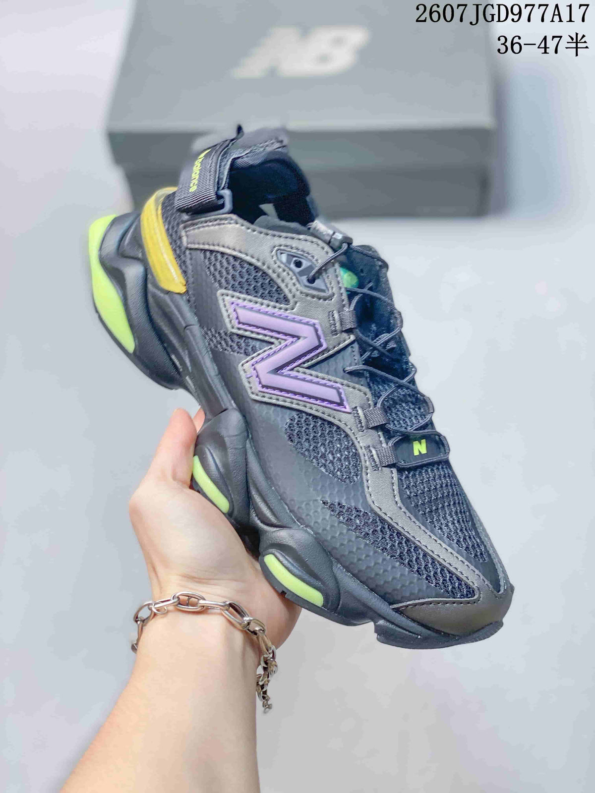 Angled side view of the black, purple and fluorescent yellow New Balance 9060 sneaker showing the mesh upper, layered overlays and thick sculpted sole.