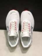 Top view of the pair showing the white perforated-looking upper, lace system, gray On logos, and red lace accents.