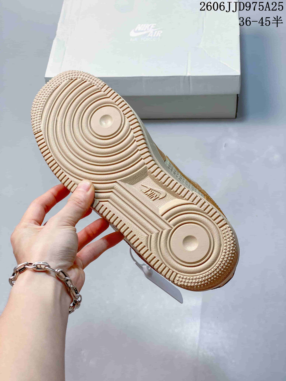 Close view of the sneaker outsole showing a cream rubber tread with concentric circular traction patterns and Nike branding.