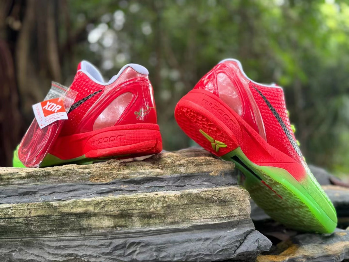 Rear and outsole views of the red and green basketball shoes, with a spare lace packet visible