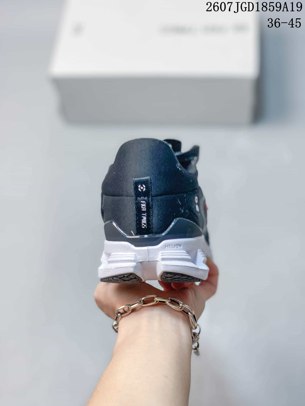 Rear view of the black sneaker showing the heel branding detail and white segmented outsole.