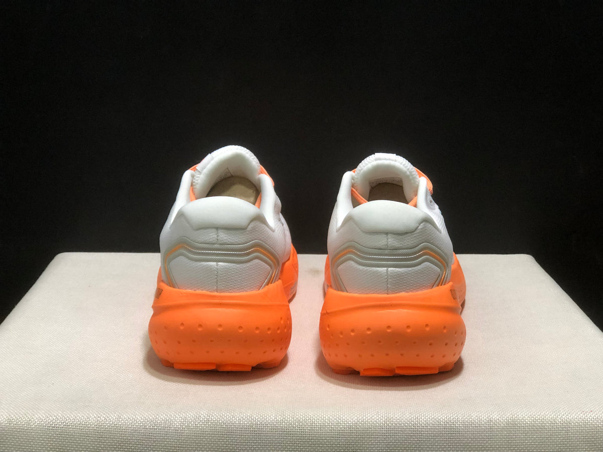 Rear view of the pair showing padded white heel sections and bright orange outsoles.