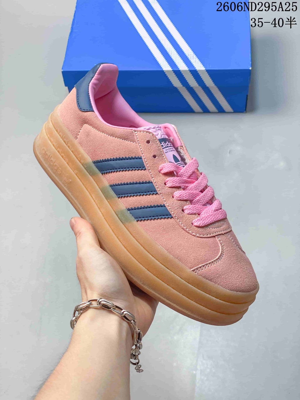 Angled side view of the pink sneaker with navy stripes, pink laces, and gum-colored platform sole.