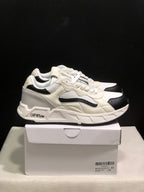 Side view of white and black low-top sneakers showing the layered upper, black accents, and branded side detail.
