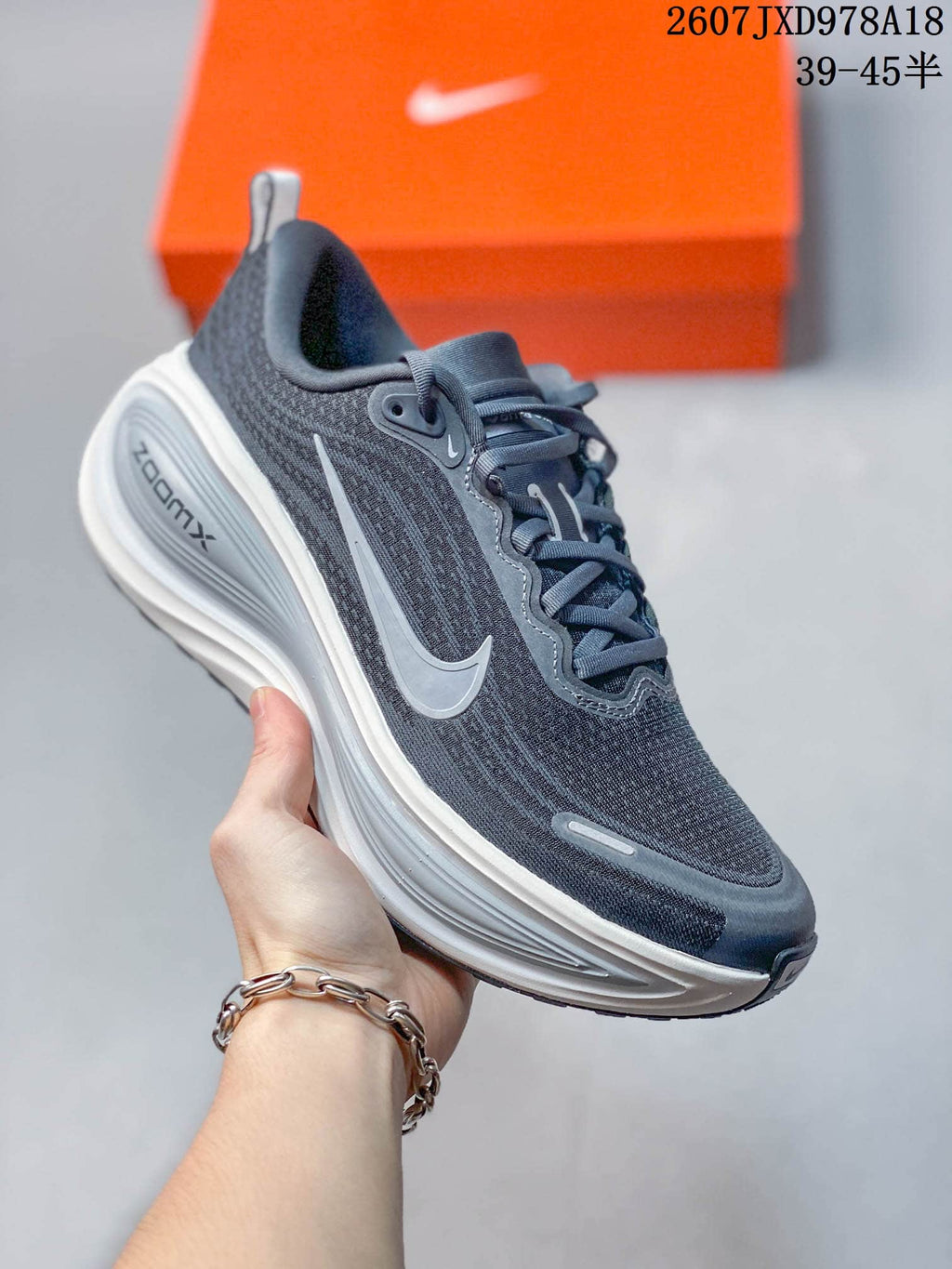 Dark gray Nike Vomero Plus running shoe with a silver swoosh and light gray midsole.