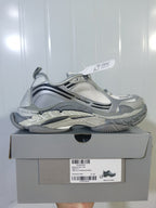 Side view of the gradient grey sneakers resting on the shoe box, with the product label visible beneath.