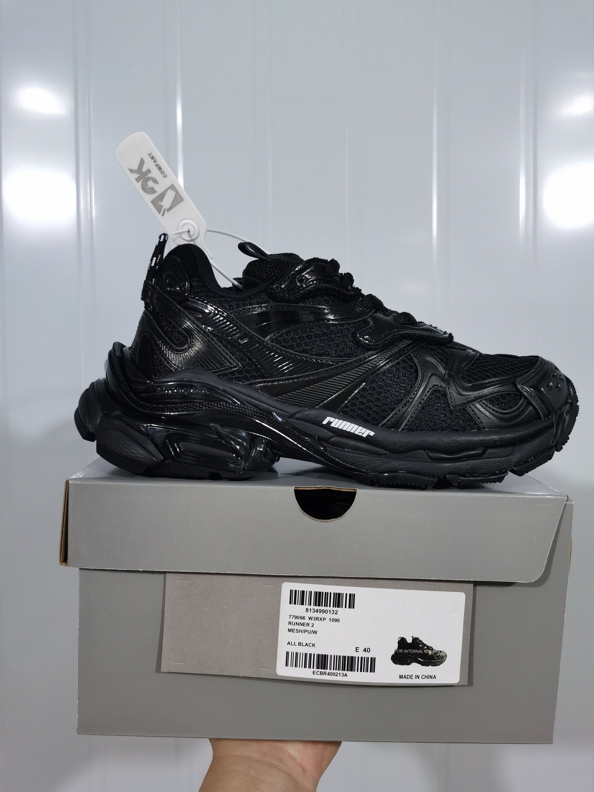 Black Puma 1090 Runner 2 sneaker displayed on its box; the label shows style 779066 W3RP 1090 Runner 2, all black, and size E 40.