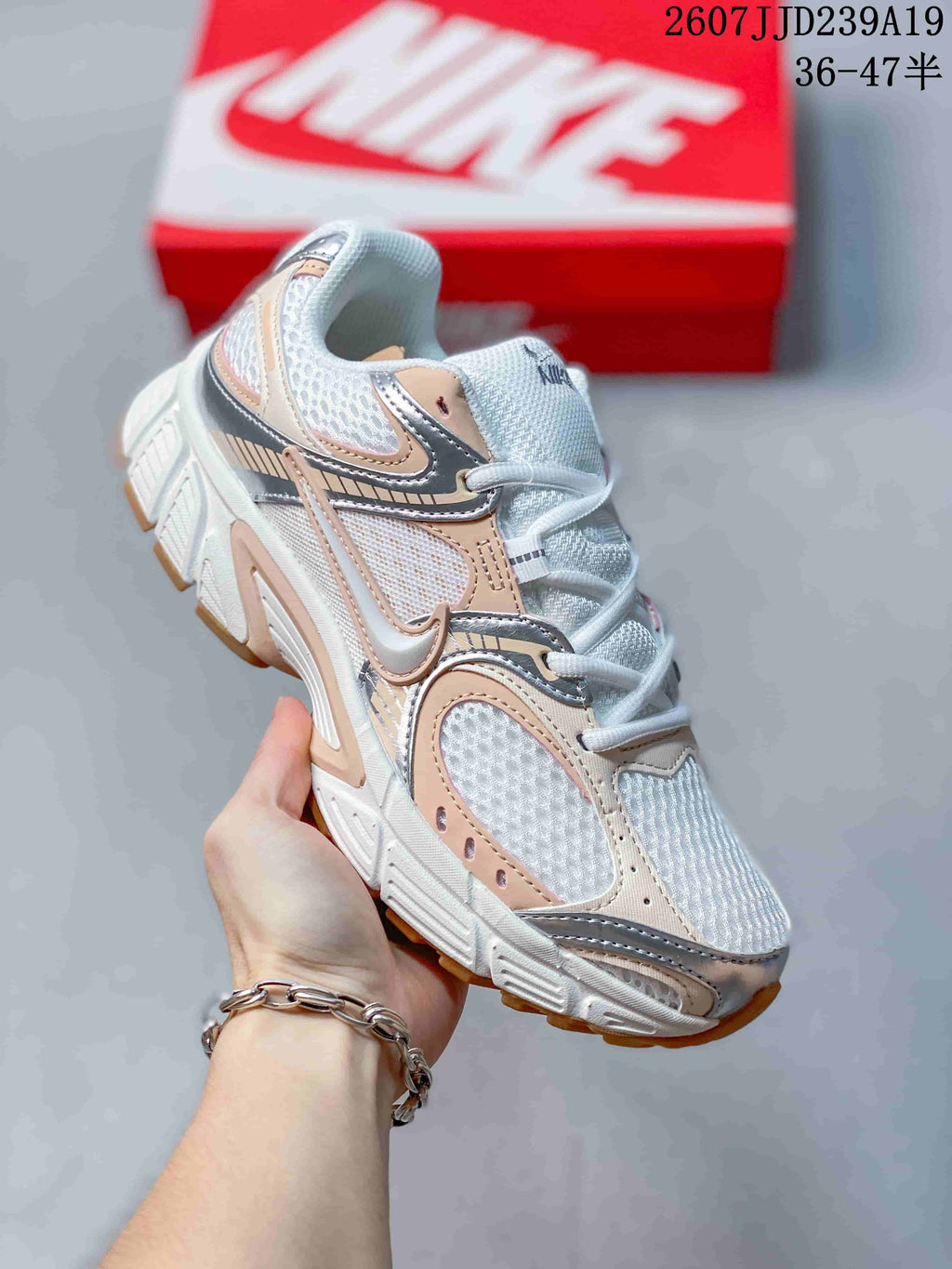 Angled side view of the white Nike V5 RNR sneaker with peach and silver overlays and a gum-toned outsole.