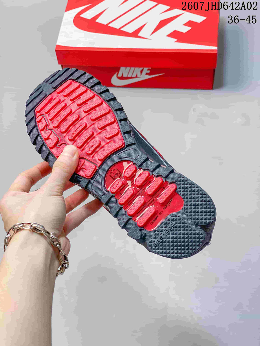 Close-up of the sneaker outsole with red and dark gray tread sections.