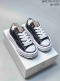 Black MMY low-top canvas sneakers with white laces and a sculpted white sole displayed on a shoebox.