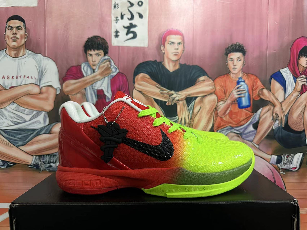 Side view of a red and volt green Nike Kobe basketball shoe with a black Swoosh and charm.