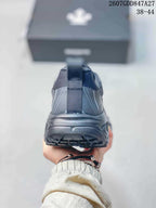 Rear view of a black sneaker showing the heel pull tab, reflective-style panel lines, and outsole.