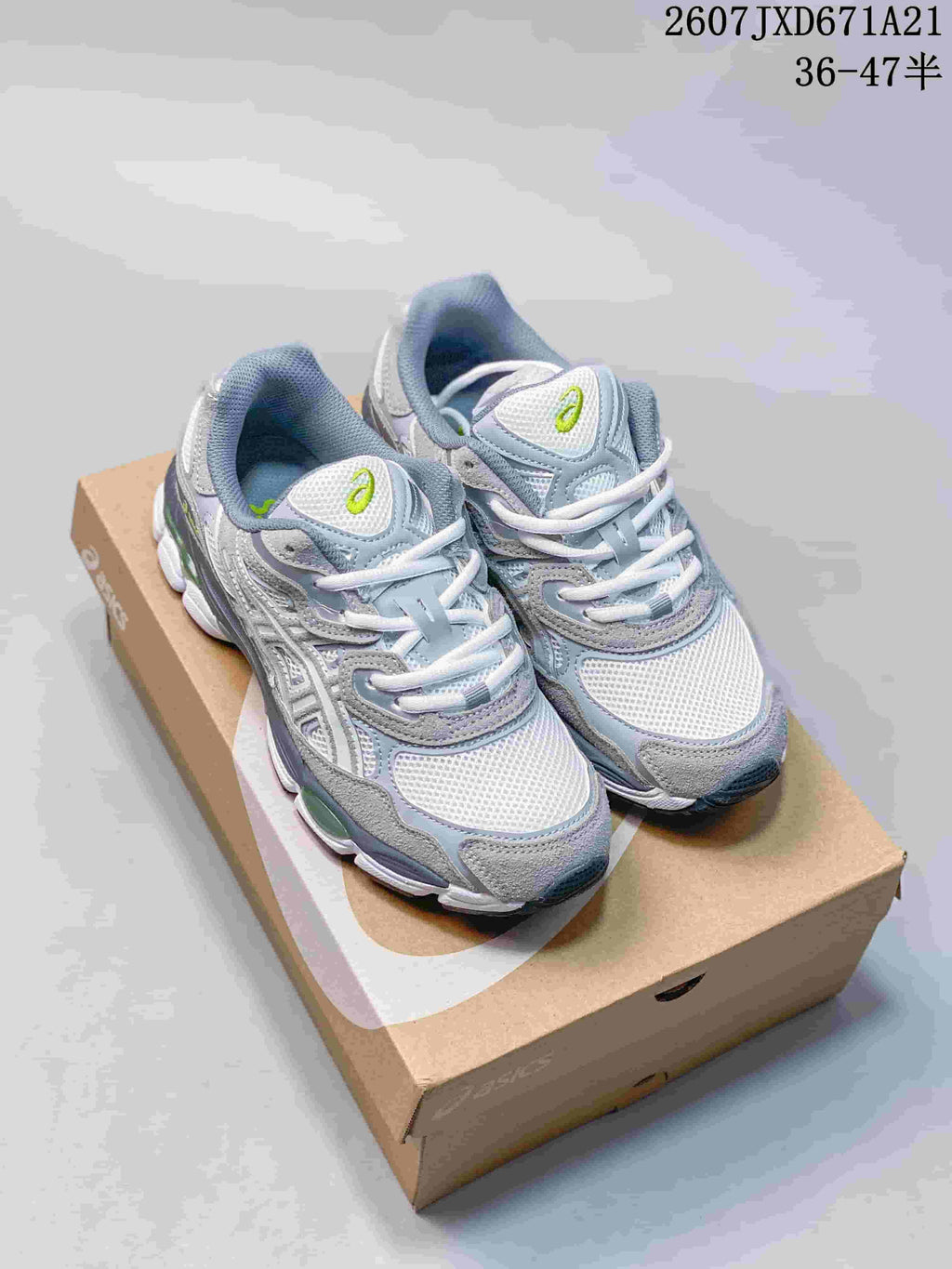 Pair of gray and white ASICS GEL-Kayano 14 sneakers with lime-green accents resting on a shoe box; overlay text shows style code 2607JXD671A21 and size range 36–47.5.