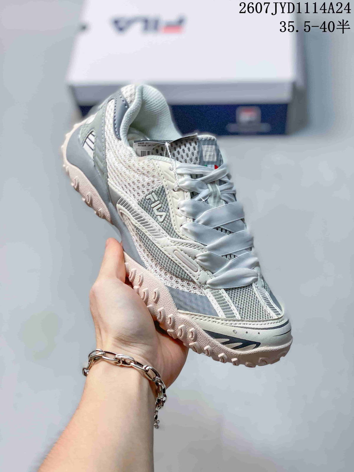 Three-quarter view of the gray and white FILA sneaker showing the side branding, layered upper, and textured sole.