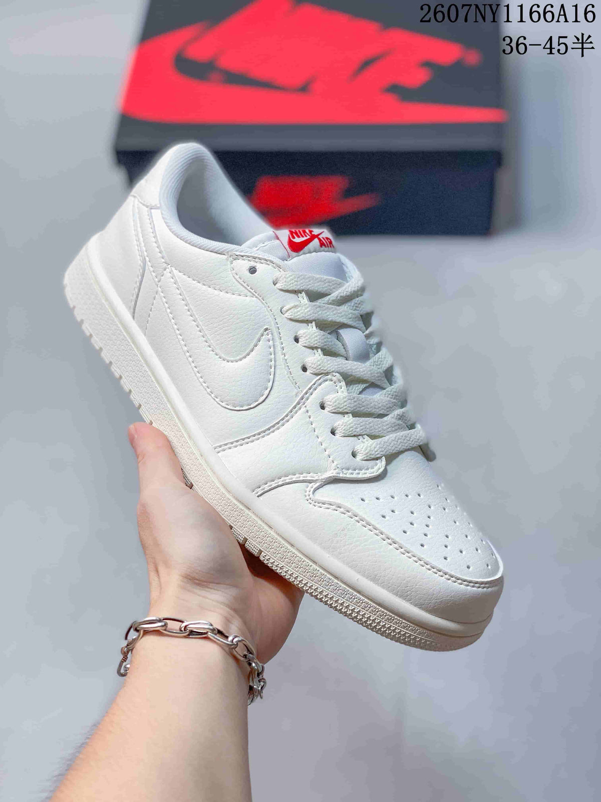 Angled side view of a white low-top sneaker showing the lace-up construction, perforated toe box, stitched side panels, and red tongue branding.