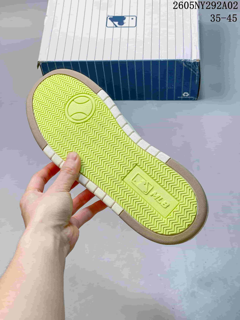 Close view of the neon-green textured outsole with a zigzag tread pattern and MLB branding.